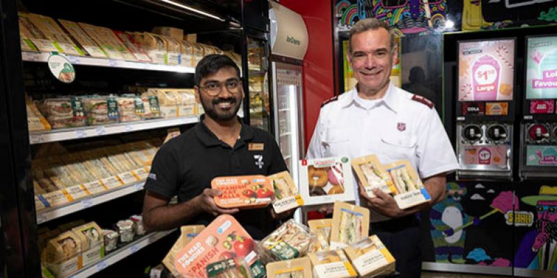 Image of store manager and member of the Salvation Army with donated food.